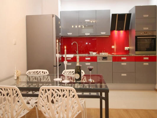 Modular modern kitchen with gray cabinets and red splash back